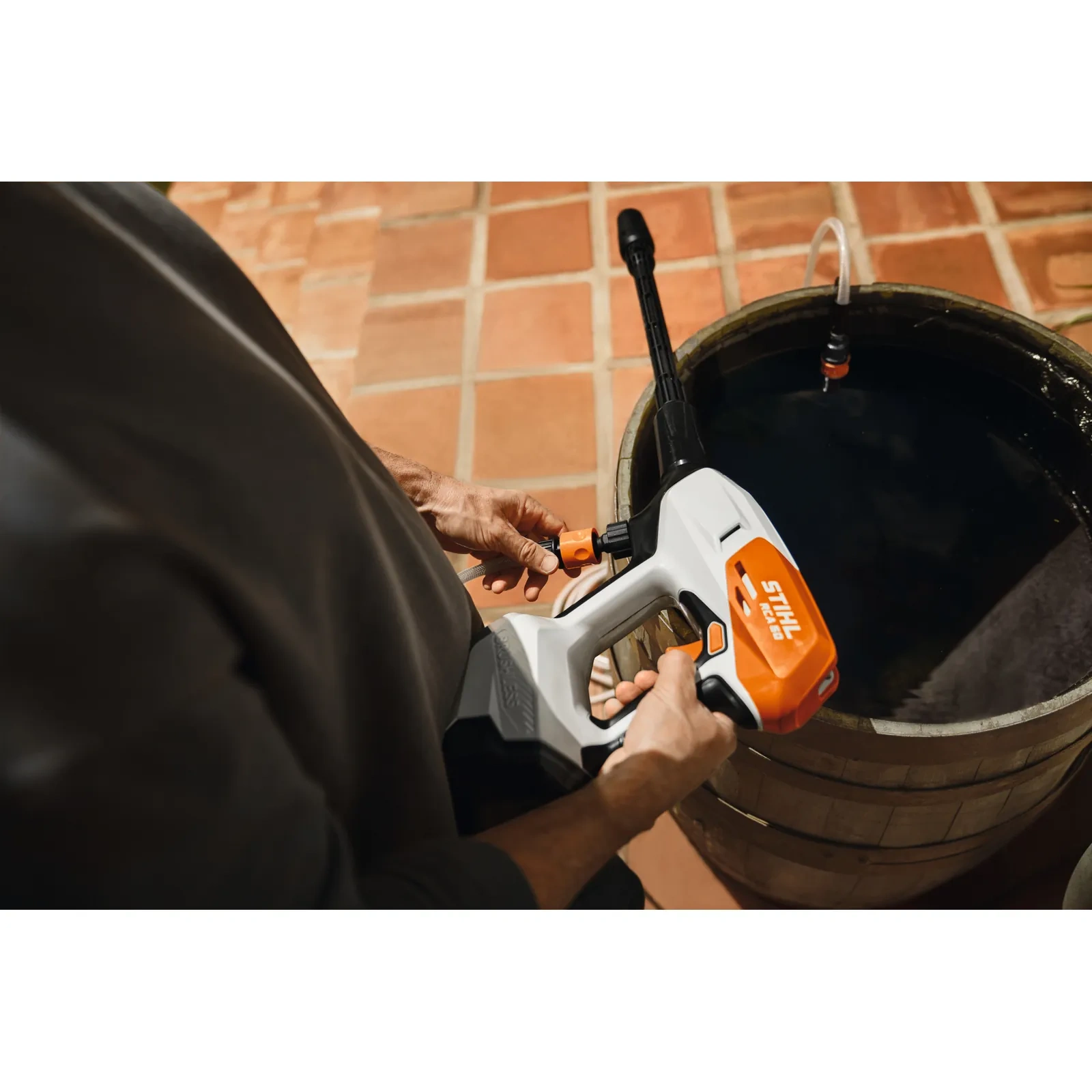 Napełnianie: wąż ssący myjki STIHL RCA 50 w drewnianej beczce z deszczówką